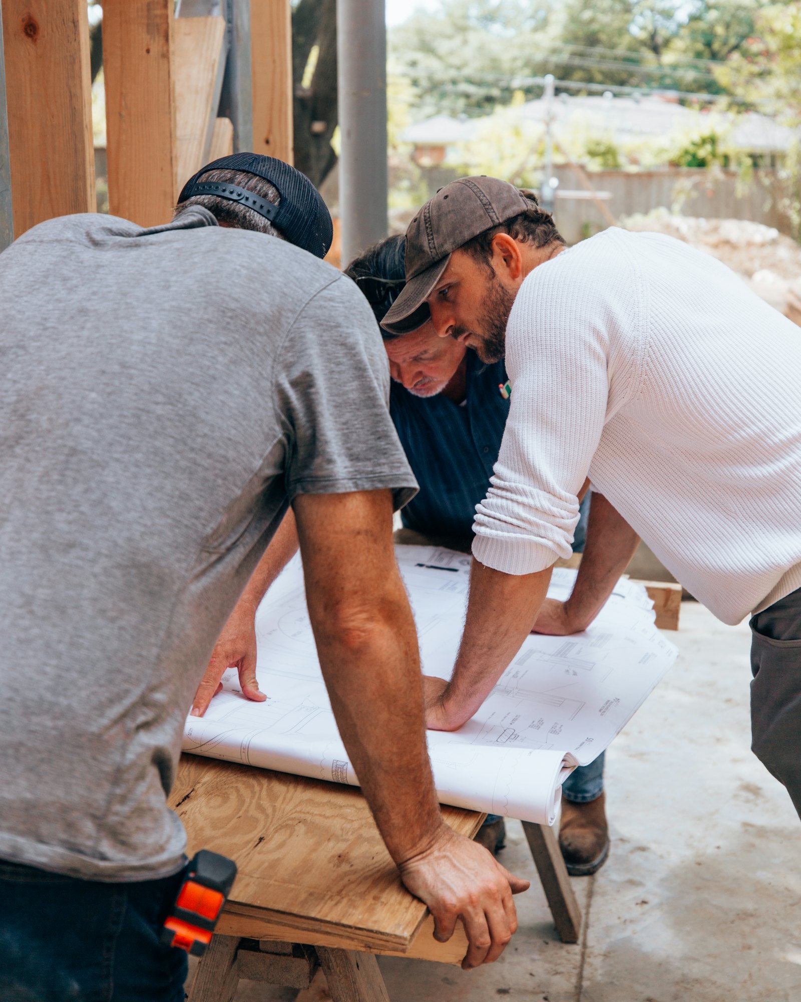 Crew gathered around plans on a job site